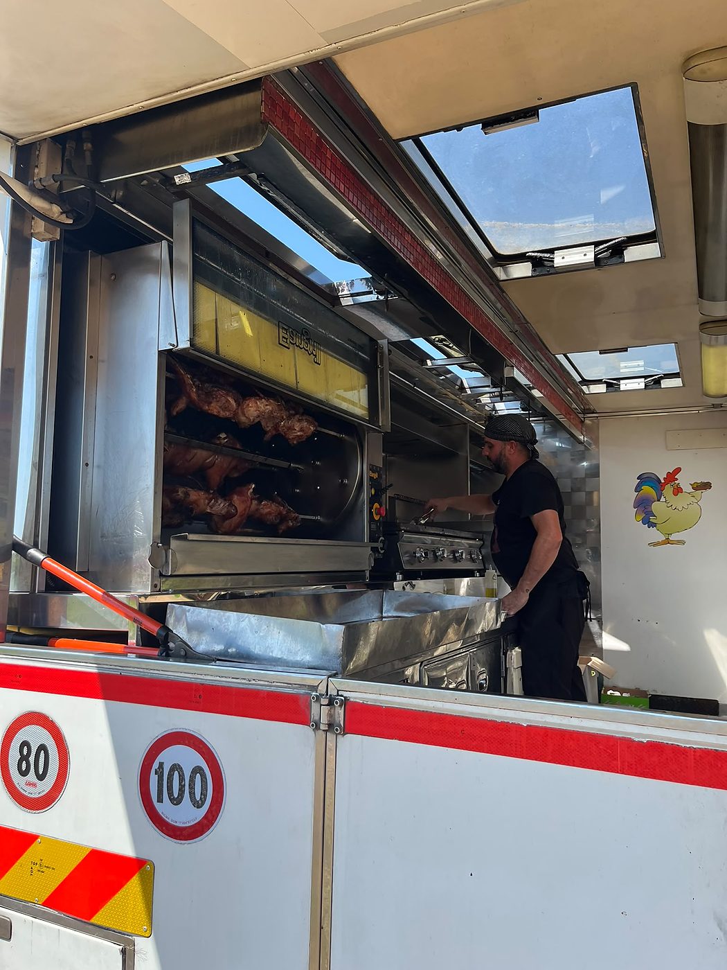 Preparazione del pollo allo spiedo nel Food Truck di Cea